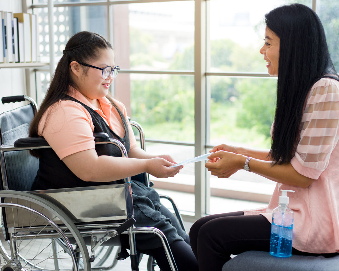An Angels of Light Healthcare caregiver sharing a warm moment with a young client in a wheelchair