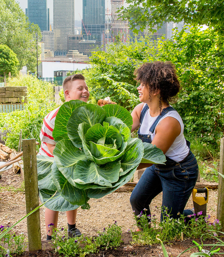 An Angels of Light Healthcare caregiver laughing with a young client in a community garden
